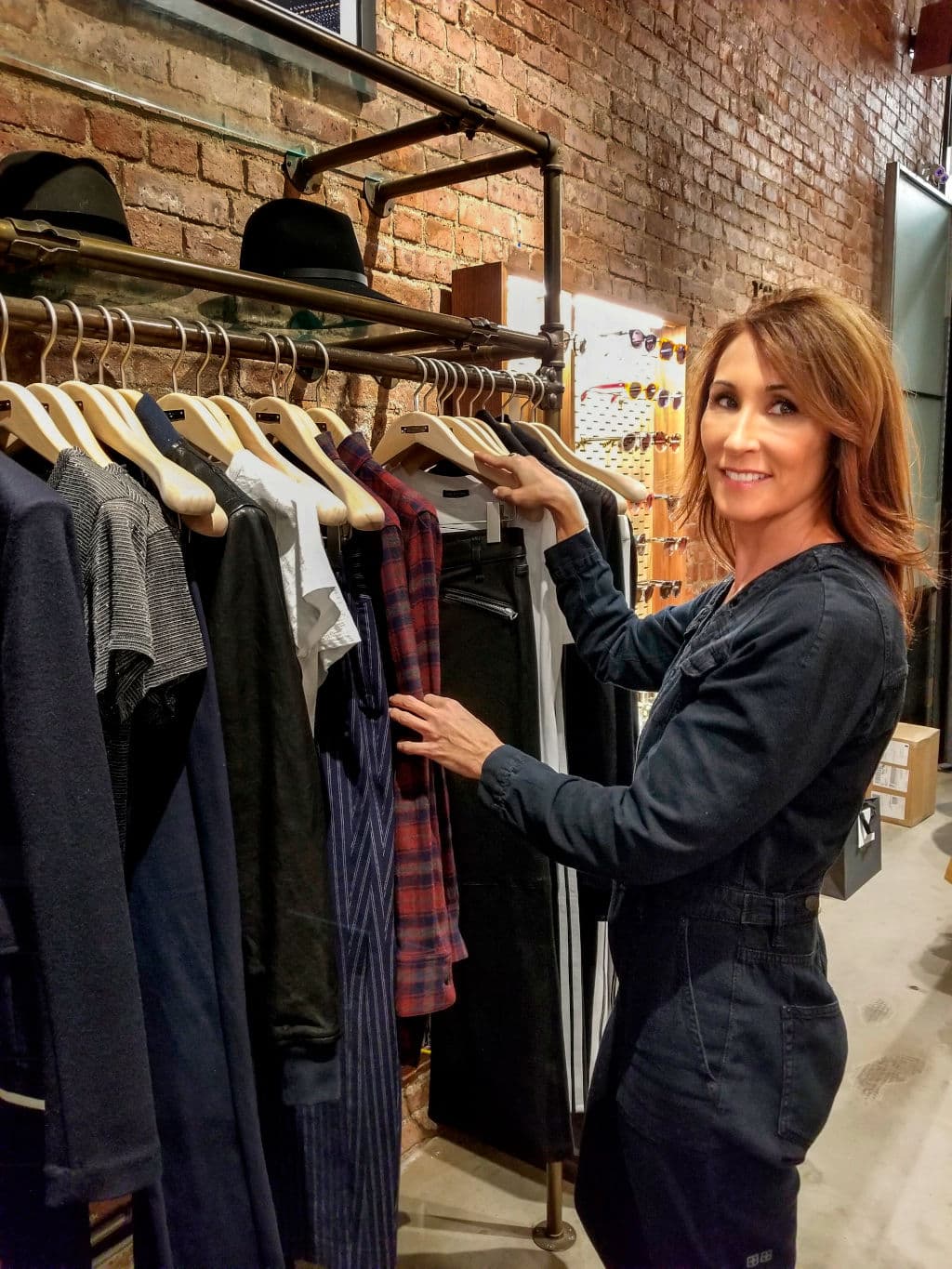 Kriena browsing curated clothing selection in boutique